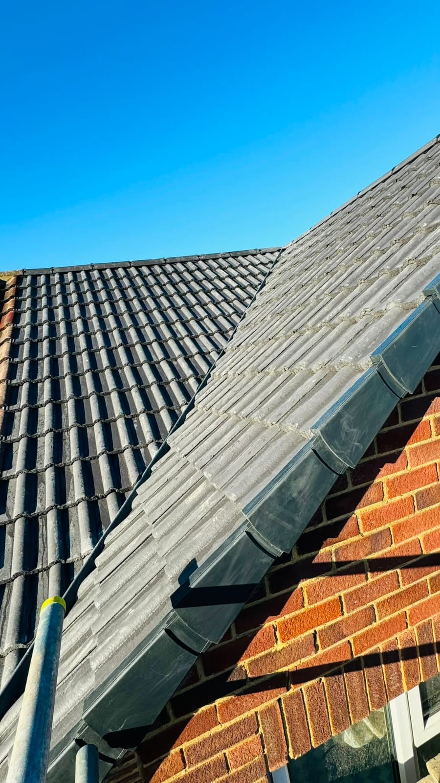Clean lead flashing detail where a roof slope meets a brick chimney